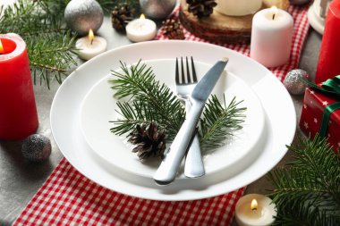 Gri masa üzerinde mumlar olan yeni yıl masa ayarı kavramı, kapat