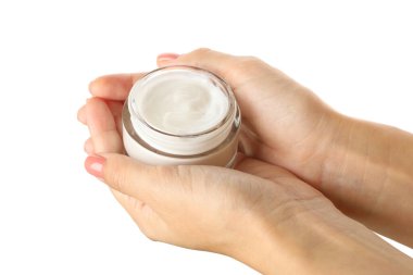 Beyaz arka planda izole edilmiş kozmetik kremli kadın elleri kavanozu tutuyor.