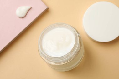 Bej arka planda bir kavanoz kozmetik kremi