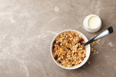 Gri arka planda granola ve süt ile kase