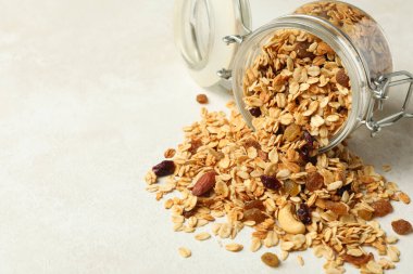 Beyaz arka planda lezzetli granola ile cam kavanoz