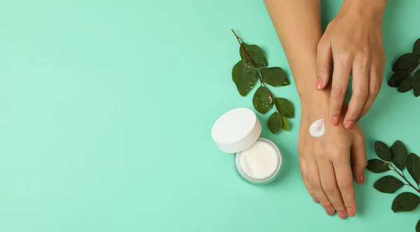 Manos Femeninas Con Crema Cosmética Sobre Fondo Menta — Foto de Stock