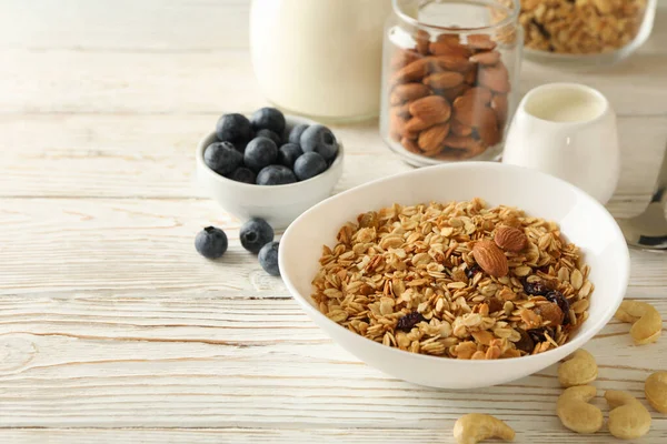 Concept of tasty breakfast with granola on wooden background