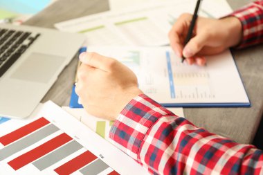 Kırmızı gömlekli genç adam mali planlama ile meşgul.