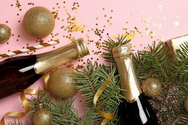 Yeni yıl aksesuarları ve pembe arka planda şampanya şişeleri.