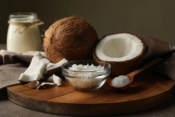 Board with coconut and coconut flakes on gray table