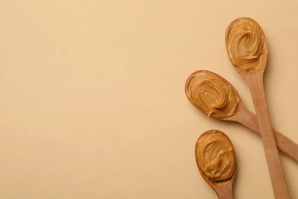 Drewniane Łyżki Masłem Orzechowym Beżowym Tle — Zdjęcie stockowe