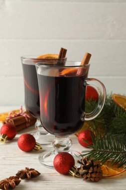 Ahşap arka planda sıcak şarap ve Noel aksesuarları.