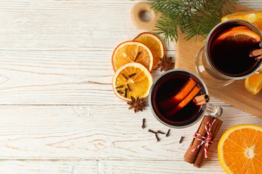 Ahşap arka planda sıcak şarap ve malzemeler.