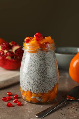 Kahvaltı kavramı ve gri masada bir kavanoz chia puding.