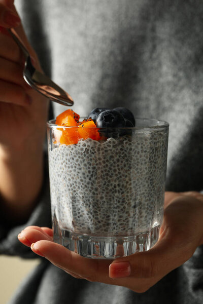 Woman in sweater eat delicious chia pudding