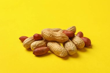 Sarı arka planda lezzetli kabuklu ve kabuksuz fıstık.