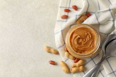 Peçeteyle fıstık ezmesi, kavanoz fıstık ezmesi ve kaşık.