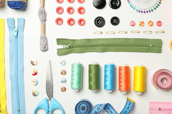 Плоская лежала со швейными принадлежностями на белом фоне