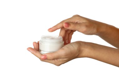 Beyaz arka planda izole edilmiş kozmetik kremli kadın elleri kavanozu tutuyor.