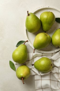 Yeşil armut tepsisi ve beyaz desenli arka planda mutfak havlusu.