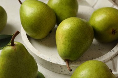 Yeşil armut tepsisi ve beyaz desenli arka planda mutfak havlusu.