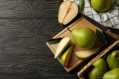 Tahta zemin üzerinde yeşil armutlar olan tahta ve sepet.