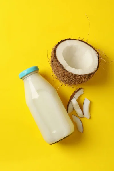 Fresh coconut and coconut milk on yellow background