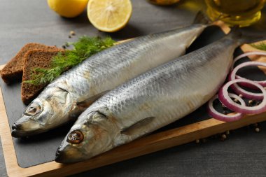 Ringa balığı, baharat ve koyu ahşap arka planda yağlı tahtalar.