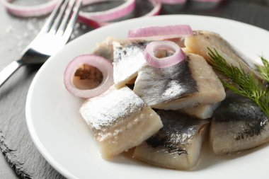 Bir tabak taze balık dilimli siyah tepsi.