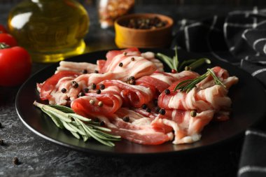 Siyah dumanlı arka planda bir tabak pastırmalı lezzetli atıştırmalık.