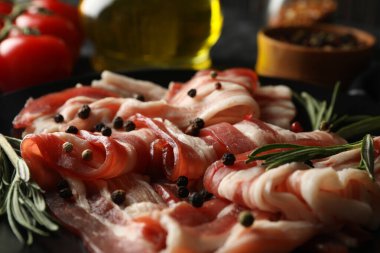 Siyah dumanlı arka planda bir tabak pastırmalı lezzetli atıştırmalık.