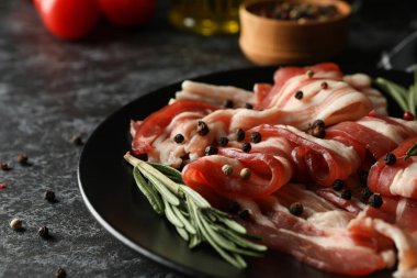 Siyah dumanlı arka planda bir tabak pastırmalı lezzetli atıştırmalık.