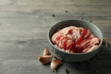 Pastırmalı kase ve gri arka planda baharatlar.