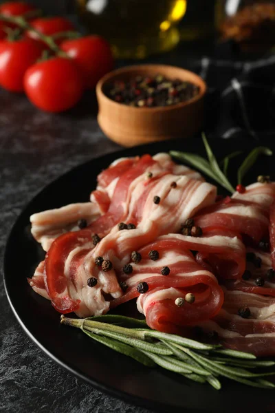 Siyah dumanlı arka planda bir tabak pastırmalı lezzetli atıştırmalık.