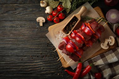 Çiğ şiş kebap ve ahşap arka planda malzemelerle barbekü pişirme kavramı