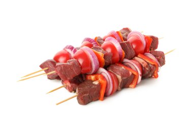 Beyaz arka planda çiğ et ve sebzeli şişler.