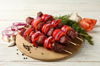 Şiş kebap ve ahşap arka planda malzemelerle tahta kesmek.