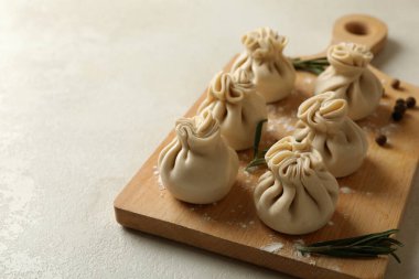 Beyaz desenli arka planda khinkali, baharat ve un olan tahta