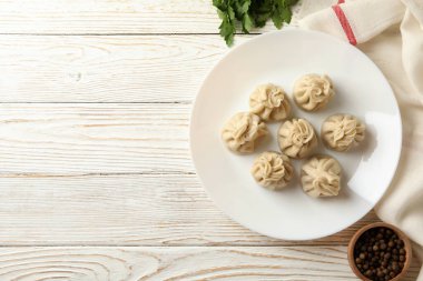 Beyaz ahşap arka planda bir tabak khinkali ile lezzetli öğle yemeği kavramı