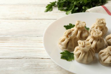 Beyaz ahşap arka planda bir tabak khinkali ile lezzetli öğle yemeği kavramı