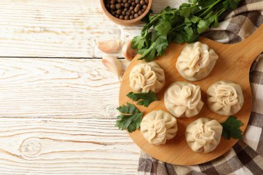 Beyaz ahşap arka planda khinkali tahtası ile lezzetli öğle yemeği kavramı