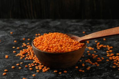 Siyah dumanlı masada kırmızı baklava desenli kase ve kaşık.