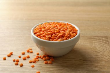 Ahşap zemin üzerinde kırmızı baklagiller olan kase, yakın çekim