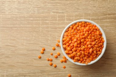 Ahşap arka planda baklagiller olan bir kase, üst manzara