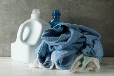 Deterjan ve buruşuk havlular gri arka plana karşı
