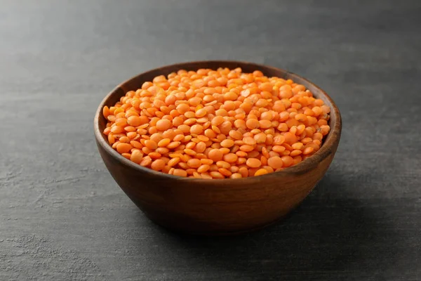 Karanlık ahşap arka planda baklagiller olan bir kase, yakın plan.