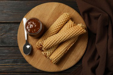 Tahta arka planda yoğunlaştırılmış sütle birlikte gofretli lezzetli yemek kavramı