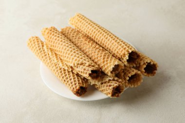 Beyaz desenli arka planda yoğunlaştırılmış sütle kaplı gofretli tabak.