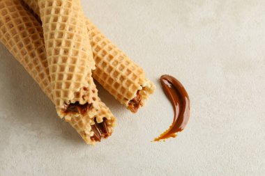 Beyaz desenli arka planda yoğunlaştırılmış sütle lezzetli gofretler.