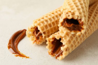 Beyaz desenli arka planda yoğunlaştırılmış sütle lezzetli gofretler.