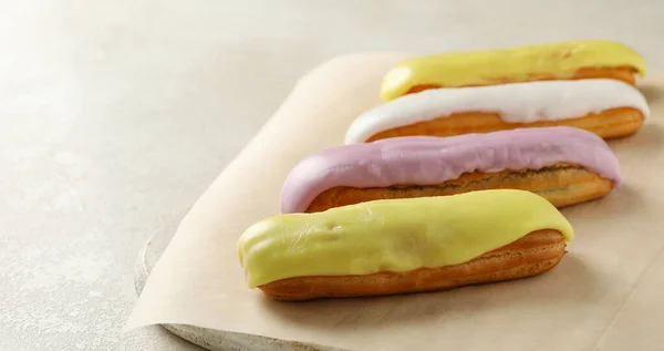 Brett Mit Eclairs Mit Pudding Auf Weißem Strukturiertem Hintergrund — Stockfoto