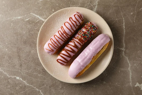 Teller Mit Eclairs Mit Pudding Auf Grauem Hintergrund — Stockfoto