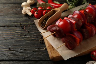 Çiğ şiş kebap ve ahşap arka planda malzemelerle barbekü pişirme kavramı