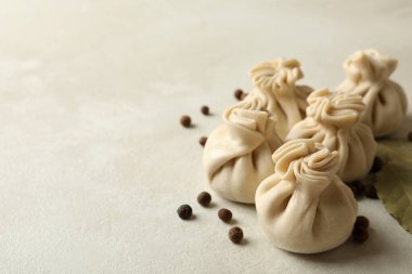 Çiğ khinkali, biber ve defne yaprakları beyaz desenli arka planda